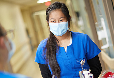 Nurse with mask standing in UMC hallway