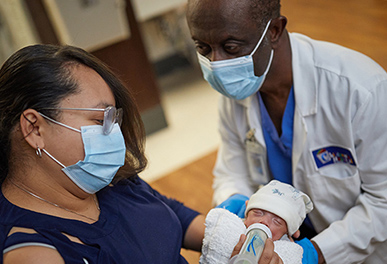 UMC doctor helping mother feed baby