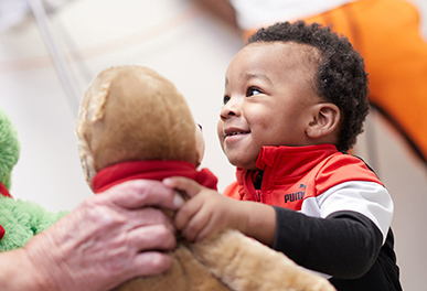 UMC volunteer giving child a teddy bear