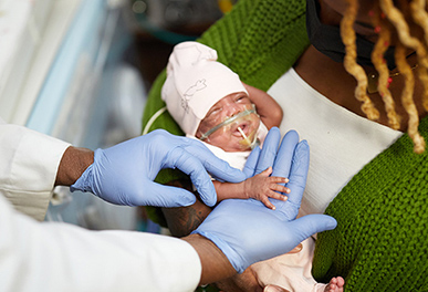 Mother holding newborn in UMC hospital room